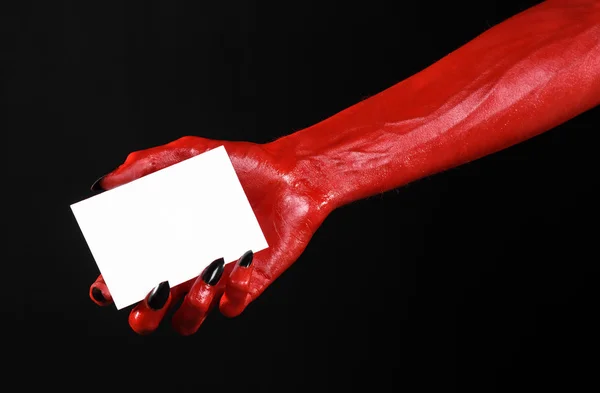 Halloween Tema: kırmızı şeytan el siyah çivi siyah bir arka plan üzerinde boş bir beyaz kart tutan — Stok fotoğraf