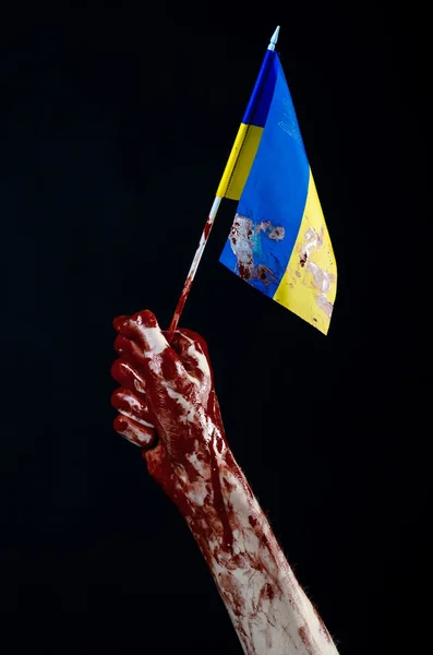 Blutige Hände, die Fahne der Ukraine im Blut, Revolution in der Ukraine, schwarzer Hintergrund — Stockfoto