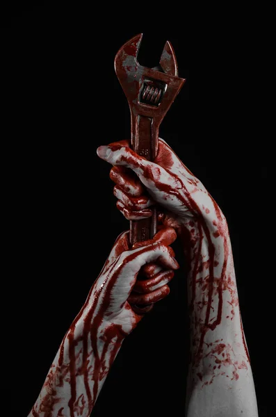 Tema di Halloween: mano insanguinata con una grande chiave inglese su sfondo nero — Foto Stock