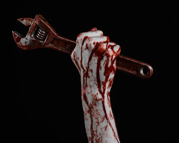 ハロウィーンのテーマ: 黒い背景に大きなレンチを保持している血まみれの手 — ストック写真