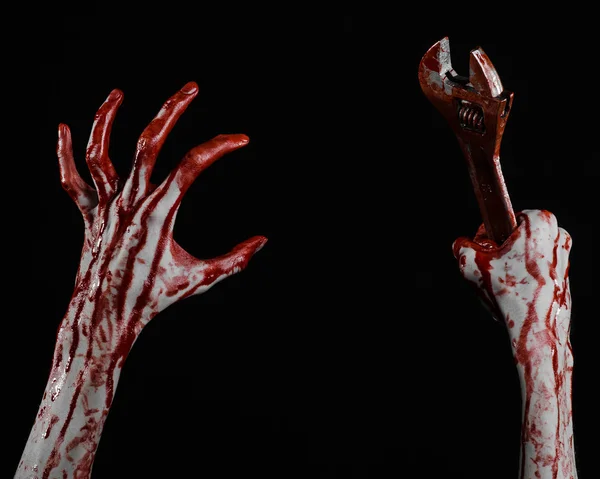 Tema Halloween: tangan berdarah memegang kunci pas besar pada latar belakang hitam — Stok Foto