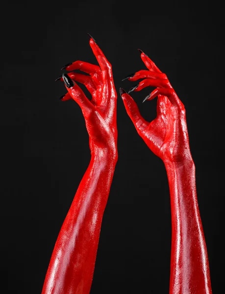 Red Devil's hands, red hands of Satan, Halloween theme, black background, isolated