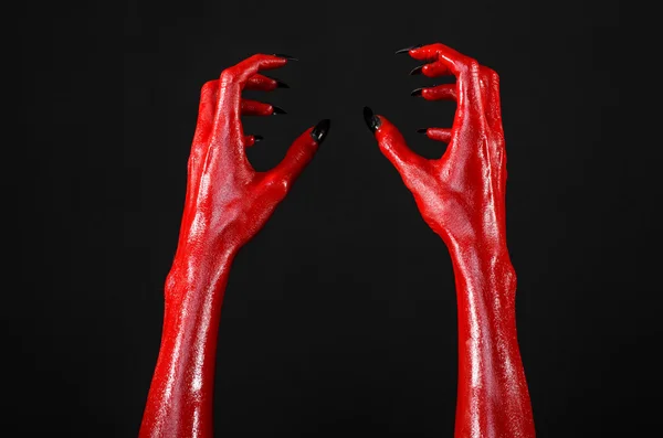 Red Devil's hands, red hands of Satan, Halloween theme, black background, isolated