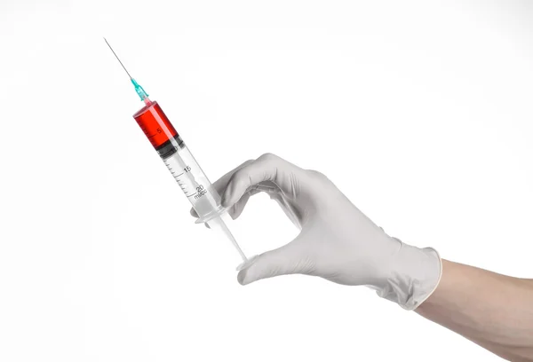 Doctor's hand holding a syringe, white-gloved hand, a large syringe, medical issue, the doctor makes an injection, white background, isolated, white gloves doctor, ebola test, red medication — Stock Photo, Image