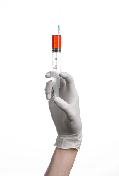 Läkarens hand håller en spruta, vita handskar handen, en stor spruta, medicinsk fråga läkaren gör en injektion, vit bakgrund, isolerade, vita handskar läkare, ebola test, röda medicinering — Stockfoto