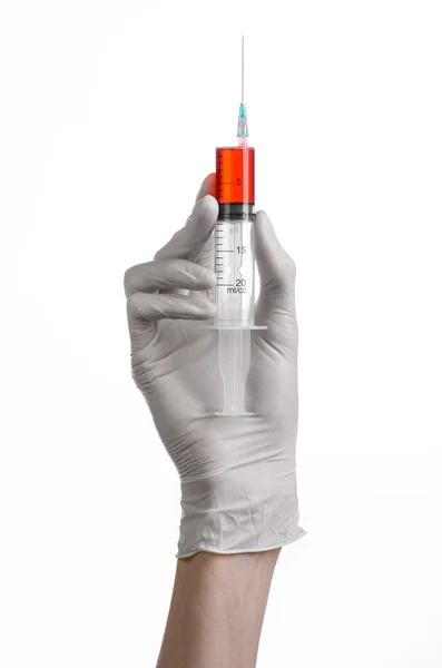 Doctor's hand holding a syringe, white-gloved hand, a large syringe, medical issue, the doctor makes an injection, white background, isolated, white gloves doctor, ebola test, red medication — Stock Photo, Image