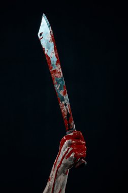 Bloody halloween theme: bloody hands holding a bloody machete isolated on black background in studio clipart