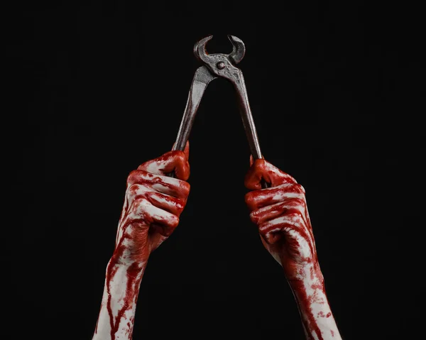 Halloween-Thema: Blutige Hand mit einer Zange auf schwarzem Hintergrund — Stockfoto