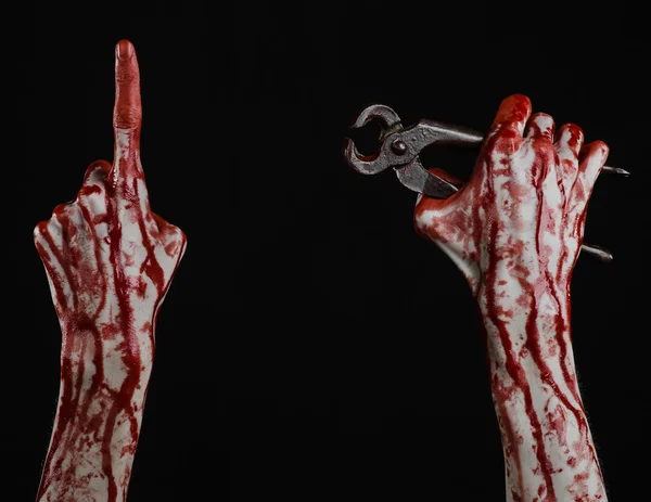 Halloween theme: bloody hand holding a pliers on a black background — Stock Photo, Image