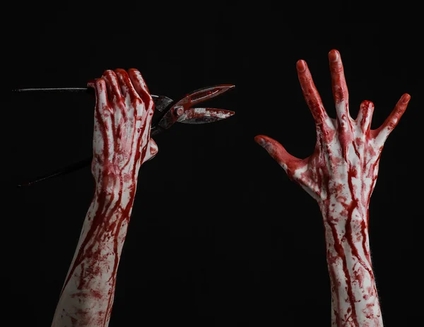 Halloween theme: bloody hand holding a big old bloody scissors on a black background — Stock Photo, Image