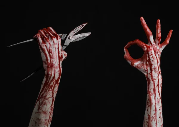 Halloween theme: bloody hand holding a big old bloody scissors on a black background — Stock Photo, Image