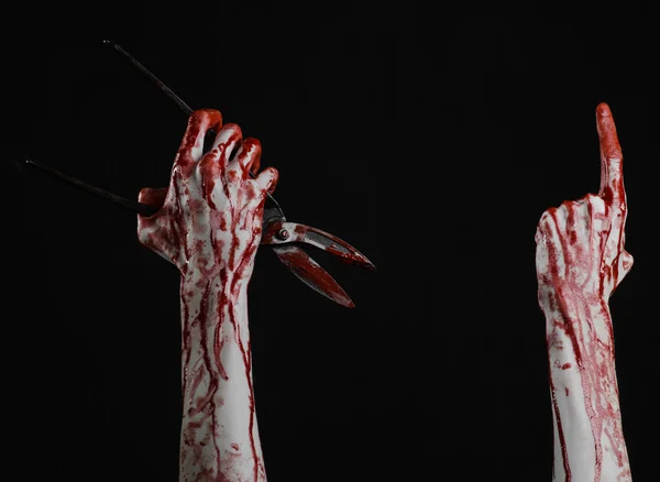 Tema de Halloween: mano sangrienta sosteniendo una tijera grande y sangrienta sobre un fondo negro — Foto de Stock