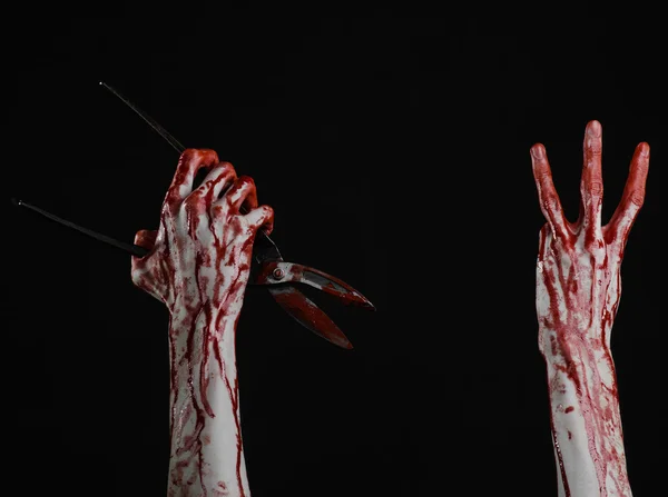 Halloween theme: bloody hand holding a big old bloody scissors on a black background — Stock Photo, Image