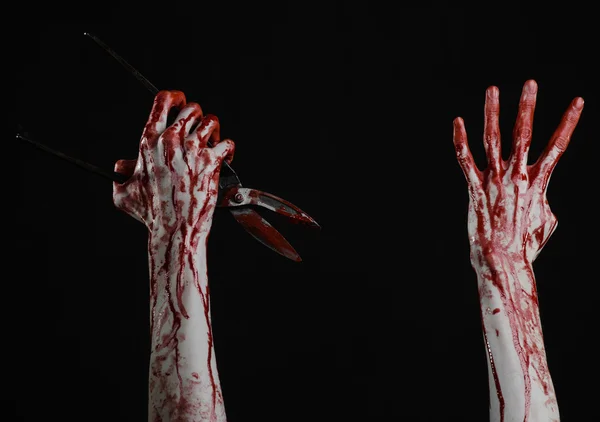 Halloween theme: bloody hand holding a big old bloody scissors on a black background — Stock Photo, Image