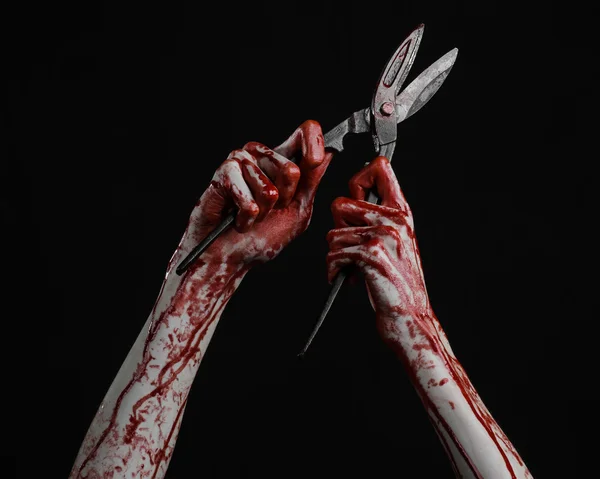 Halloween theme: bloody hand holding a big old bloody scissors on a black background — Stock Photo, Image