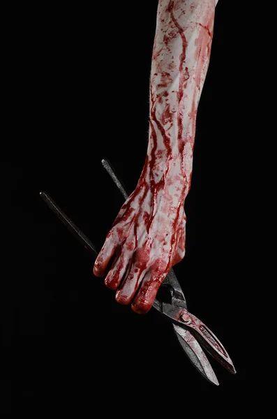 Halloween theme: bloody hand holding a big old bloody scissors on a black background — Stock Photo, Image