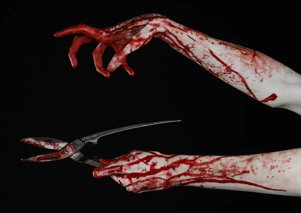 Halloween theme: bloody hand holding a big old bloody scissors on a black background — Stock Photo, Image