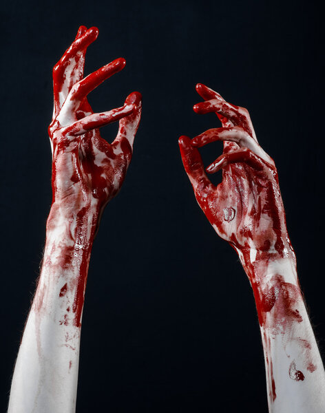 Bloody halloween theme: bloody hands killer zombie isolated on black background in studio