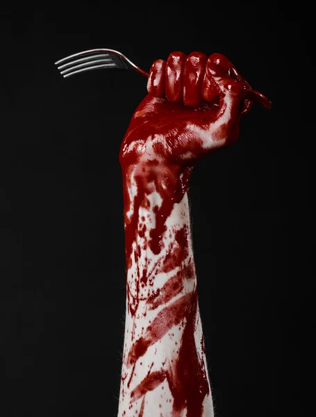 Bloody hand holding a spoon, fork, halloween theme, bloody spoon, fork, black background, isolated — Stock Photo, Image