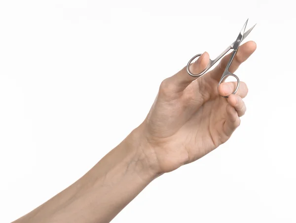 Zdravotnictví a osobní péče: ruka drží nůžky na manikúru izolovaných na bílém pozadí — Stock fotografie