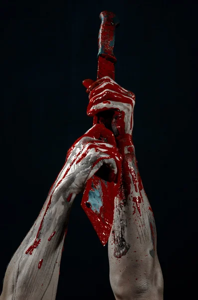 Bloody halloween theme: bloody hands holding a bloody machete isolated on black background in studio — Stok Foto