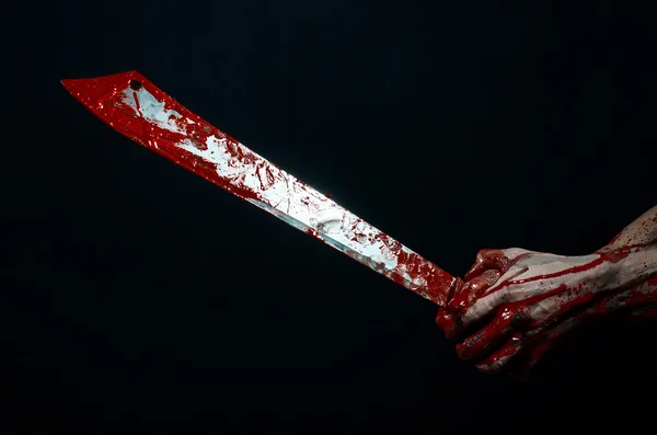 Bloody halloween theme: bloody hands holding a bloody machete isolated on black background in studio — Stock Photo, Image