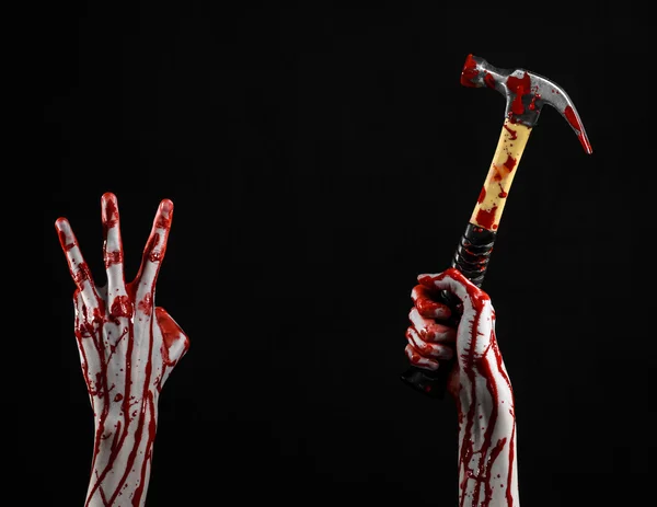 Blutiges Halloween-Thema: Blutige Hand mit blutigem Hammer auf schwarzem Hintergrund — Stockfoto