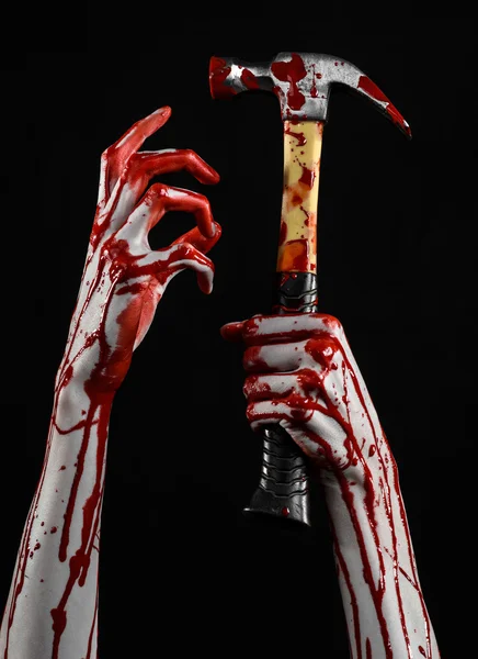 Bloody halloween theme: bloody hand holding a bloody hammer isolated on a black background — Stock Photo, Image