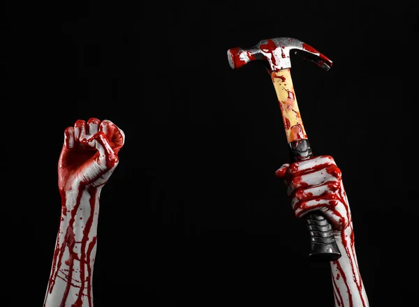 Bloody halloween téma: krvavá ruka drží krvavé kladivo izolovaných na černém pozadí — Stock fotografie