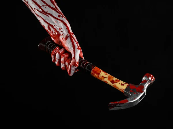 Tema de Halloween sangriento: Mano sangrienta sosteniendo un martillo sangriento aislado sobre un fondo negro — Foto de Stock