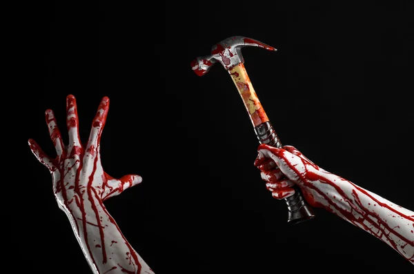 Bloody halloween theme: bloody hand holding a bloody hammer isolated on a black background — Stock Photo, Image