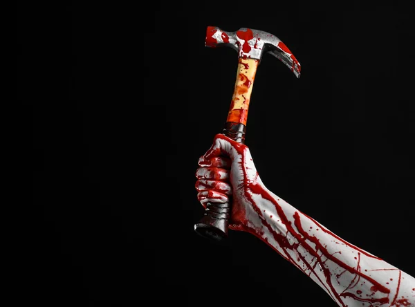 Sangrento tema halloween: mão sangrenta segurando um martelo sangrento isolado em um fundo preto — Fotografia de Stock