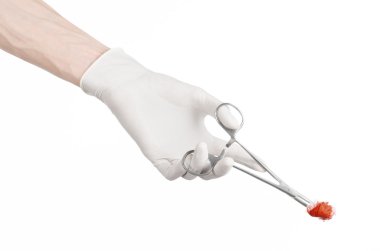 Cerrahi ve tıbbi Tema: Studio beyaz bir arka plan üzerinde izole kanlı tampon ile cerrahi klipi holding beyaz eldiven doktorun elinde