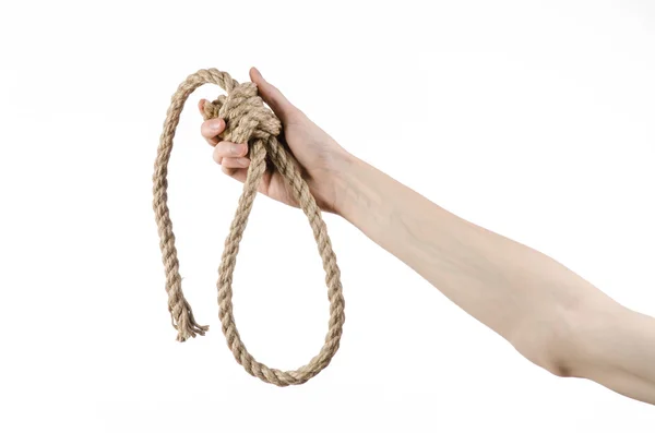 Tema de linchamiento y suicidio: la mano del hombre sostiene un lazo de cuerda para colgar sobre un fondo blanco aislado —  Fotos de Stock