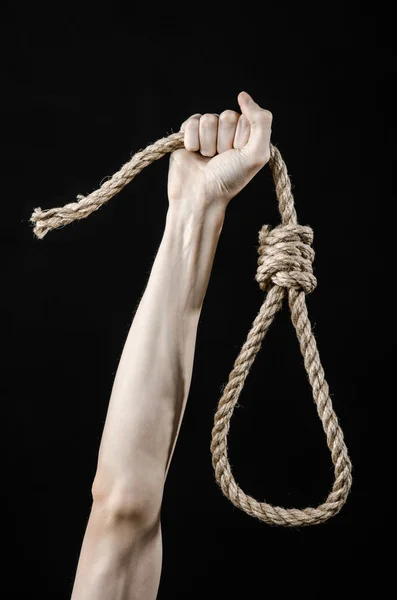 Lynching e suicidio tema: mano dell'uomo che tiene un cappio di corda per appendere su sfondo nero isolato — Foto Stock