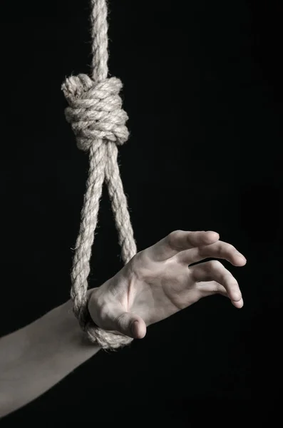 Suicide et dépression thème : main humaine suspendue à une boucle de corde sur un fond noir — Photo