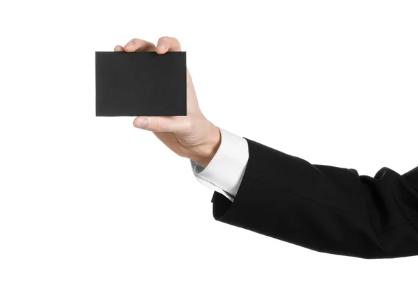 Sujet affaires et publicité : Homme en costume noir tenant une carte noire vierge à la main isolé sur fond blanc en studio — Photo