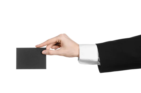 Topik bisnis dan iklan: Pria berjas hitam memegang kartu kosong hitam di tangan terisolasi dengan latar belakang putih di studio — Stok Foto