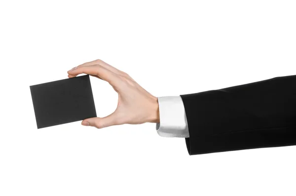 Тема бизнеса и рекламы: Человек в черном костюме с черной бланковой карточкой в руке, изолированный на белом фоне в студии — стоковое фото