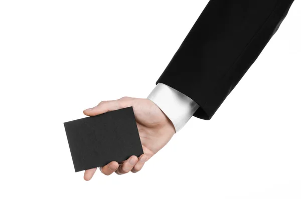 Argomento commerciale e pubblicitario: Uomo in abito nero con una carta bianca nera in mano isolata su sfondo bianco in studio — Foto Stock