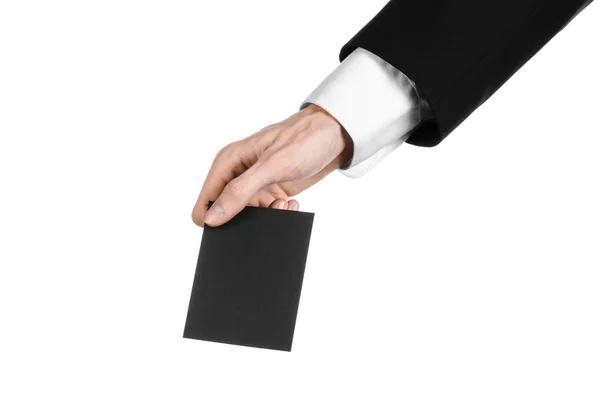 Business and advertising topic: Man in black suit holding a black blank card in hand isolated on white background in studio — Stock Photo, Image