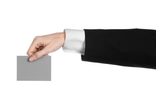 Business en reclame onderwerp: Man in zwart pak met een grijze lege kaart in hand geïsoleerd op een witte achtergrond in studio — Stockfoto