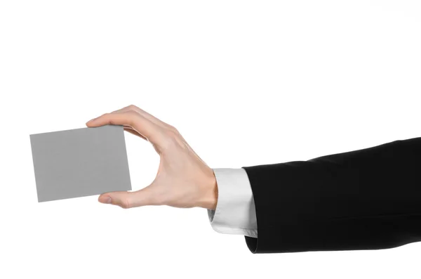 Business and advertising topic: Man in black suit holding a gray blank card in hand isolated on white background in studio — Stock Photo, Image