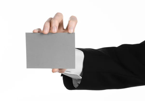 Tópico de negócios e publicidade: Homem de terno preto segurando um cartão em branco cinza na mão isolado em fundo branco em estúdio — Fotografia de Stock