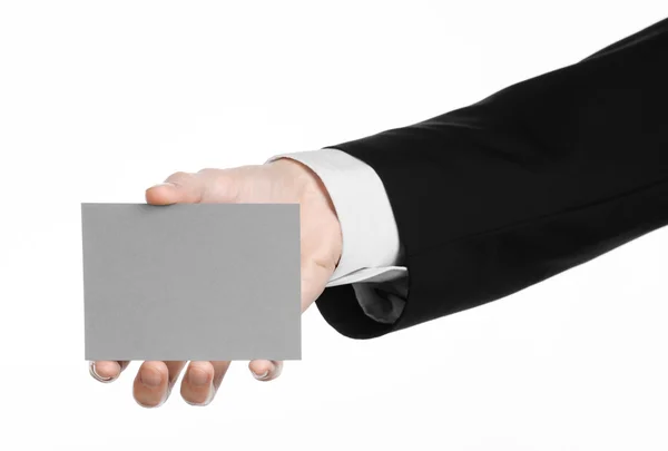 Business and advertising topic: Man in black suit holding a gray blank card in hand isolated on white background in studio — Stock Photo, Image