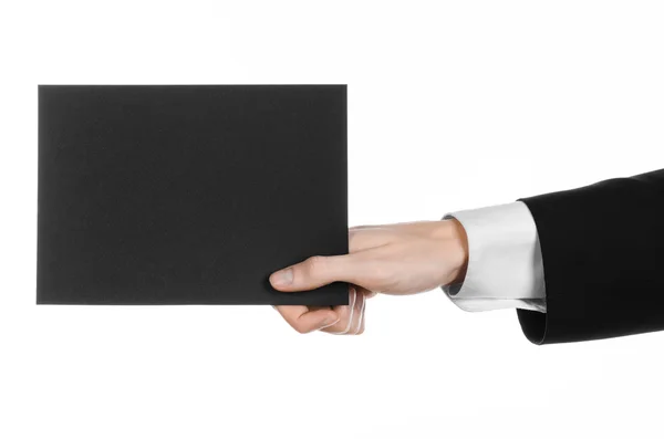 Business and advertising topic: Man in black suit holding a black blank card in hand isolated on white background in studio — Stock Photo, Image