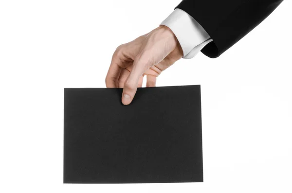 Business and advertising topic: Man in black suit holding a black blank card in hand isolated on white background in studio — Stock Photo, Image