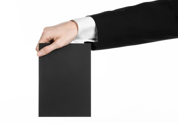Argomento commerciale e pubblicitario: Uomo in abito nero con una carta bianca nera in mano isolata su sfondo bianco in studio — Foto Stock