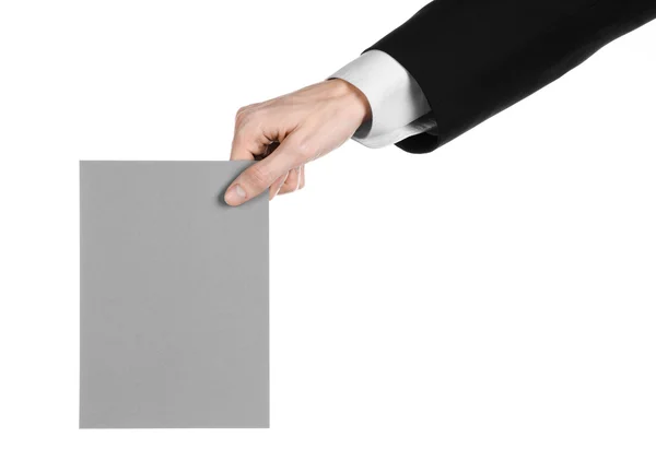 业务和广告主题: 孤立在工作室中的白色背景上的手里拿着一个灰色的空白卡的黑色西装的男人 — 图库照片