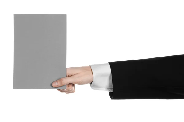 Business and advertising topic: Man in black suit holding a gray blank card in hand isolated on white background in studio — Stock Photo, Image